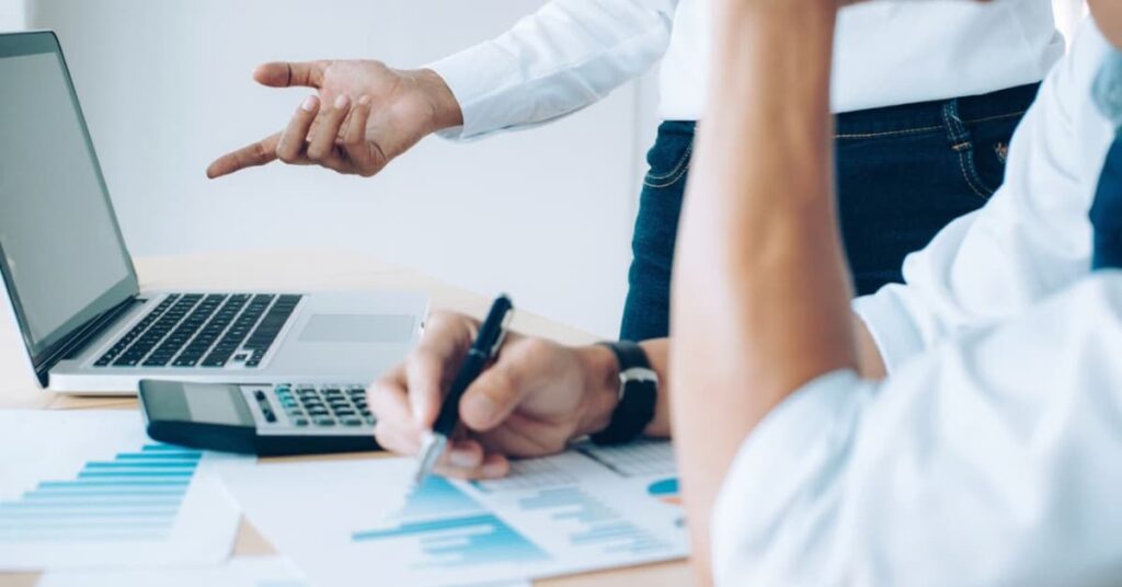Autónomo revisando documentos y cálculos en su escritorio para preparar la declaración de la renta y evitar errores fiscales.