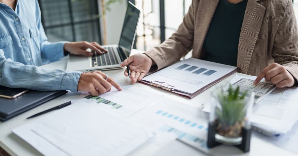 Asesor fiscal revisando documentación financiera y gráficos para la presentación del impuesto sobre sociedades.